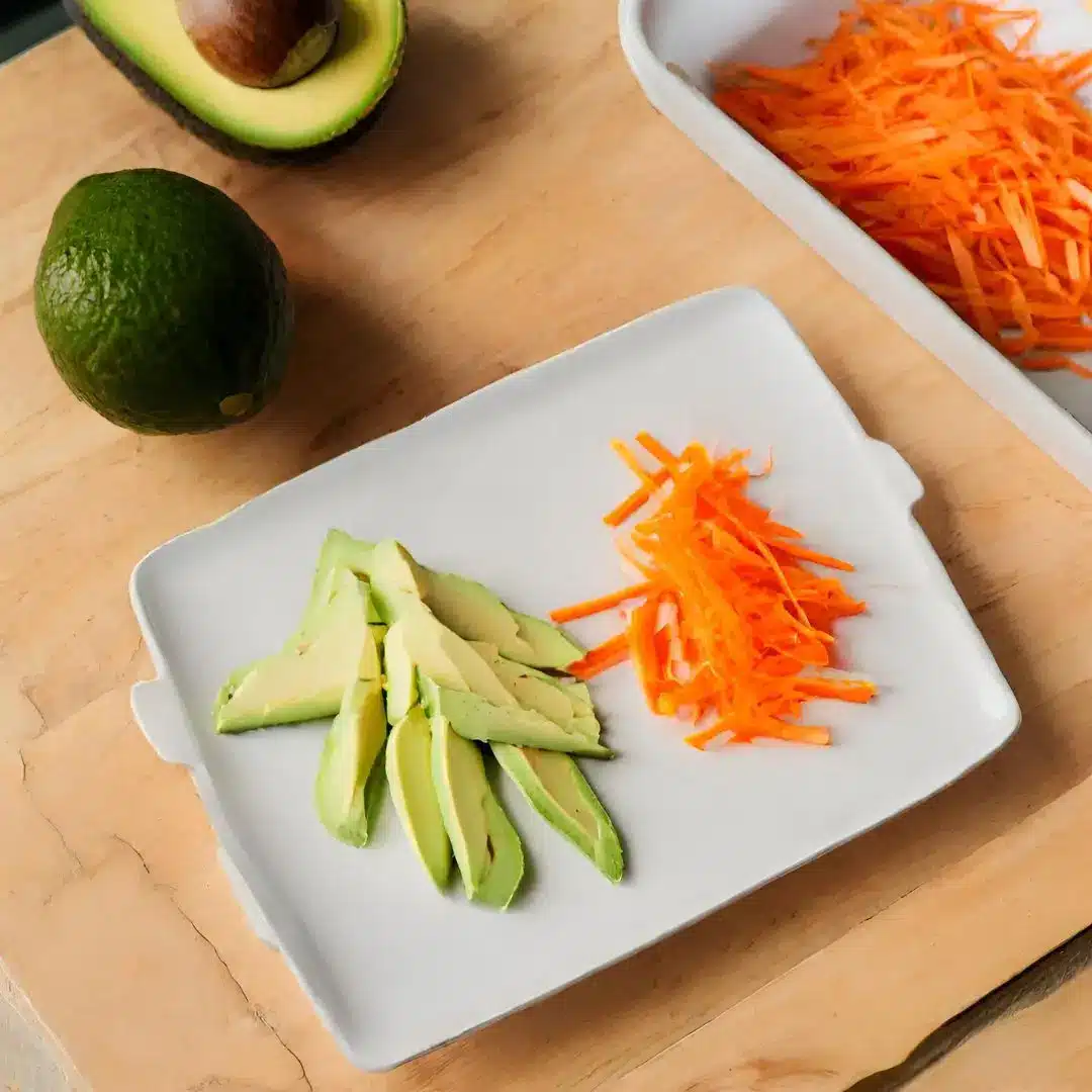 Piatto di avocado e carote tagliate, ideale per una dieta equilibrata e ricca di nutrienti.
