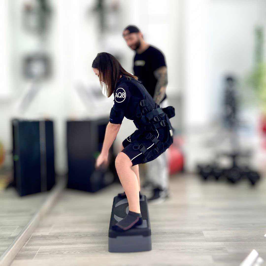Una cliente durante una sessione di EMS guidata da un personal trainer del team Novafit.