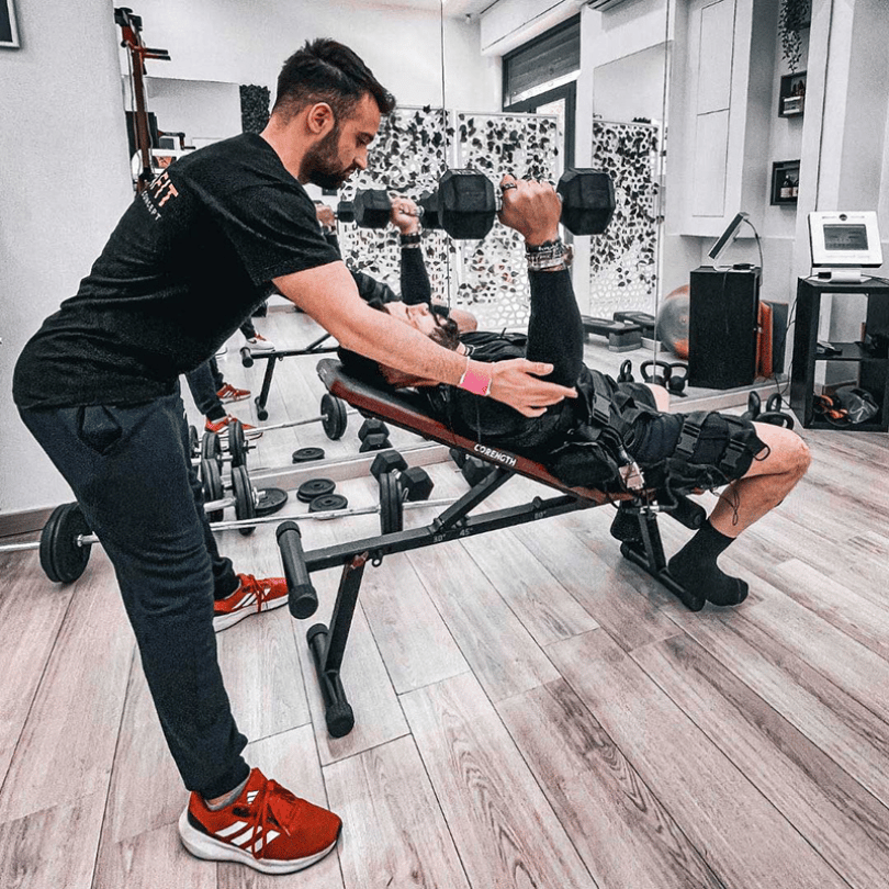 Un cliente durante una sessione di allenamento EMS con elettrodi posizionati su diverse parti del corpo presso NOVAFIT.